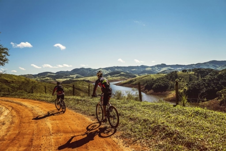 two people riding a bike on a trail
